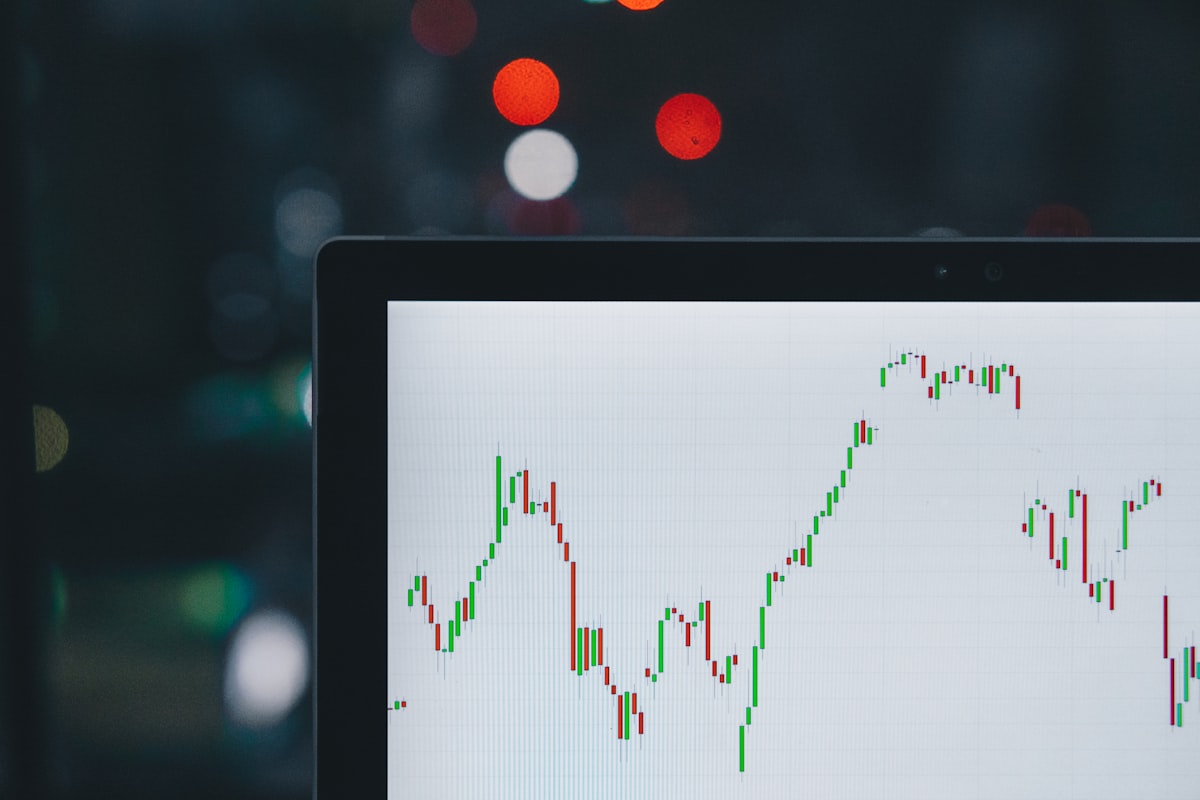 Laptop displaying stock market candlestick charts